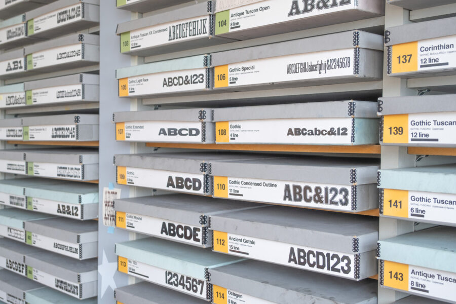 The boxes of type containing typesets from the RRK Collection, stored in the Design Lab office. The boxes have different colored labels for the different style categories.