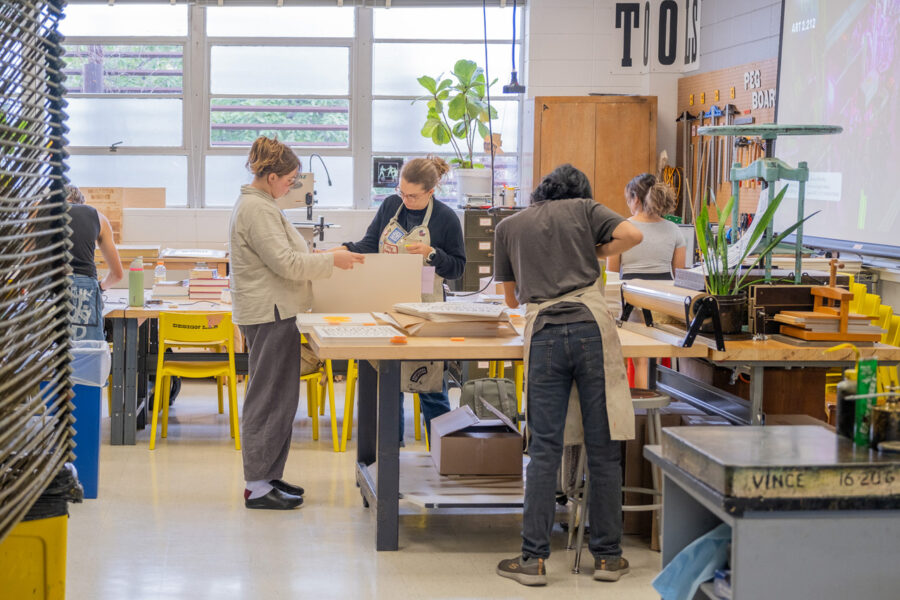 Students and staff working during the RRK summer residency in 2024. They are sorting and organizing stacks of prints.