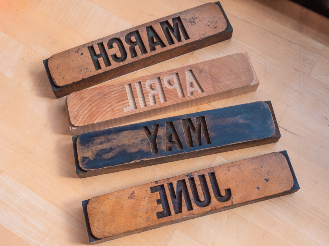 Four blocks from the calendar set sitting on a wood counter surface. March, April, May, and June are displayed.