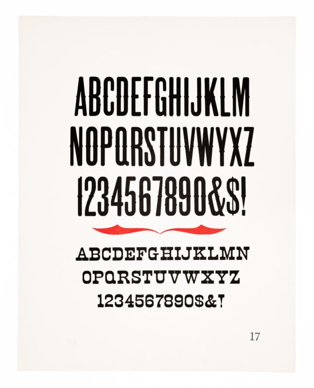 A gothic style typeface and an antique style typeface printed in black, with red framing ornaments sandwiched between the two printed in red on white paper