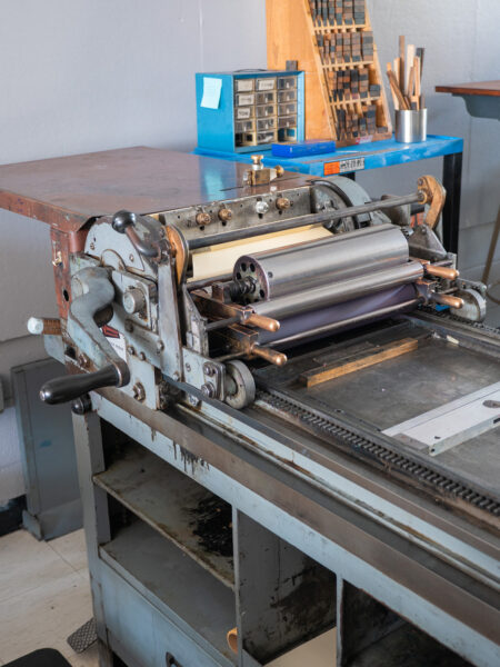 A closeup of the Vandercook No. 4 crank and roller system attached to the cylinder. The rollers are made of both steel and rubber.