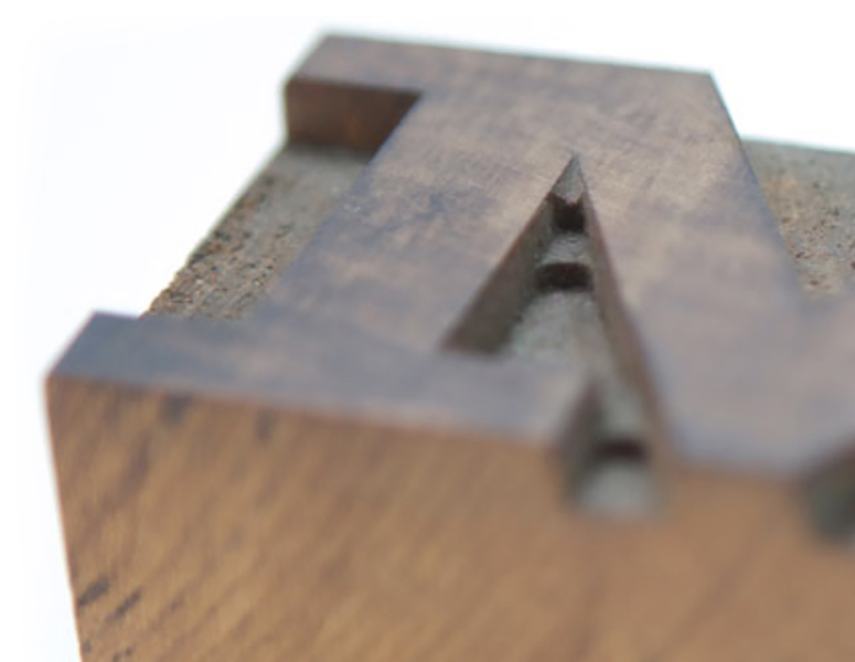 wood type block of letter M made using the router cut method from the side