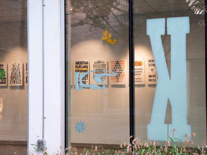 A large letter K and an index are applied to a window in white vinyl. Letterpress prints are visible inside the window.